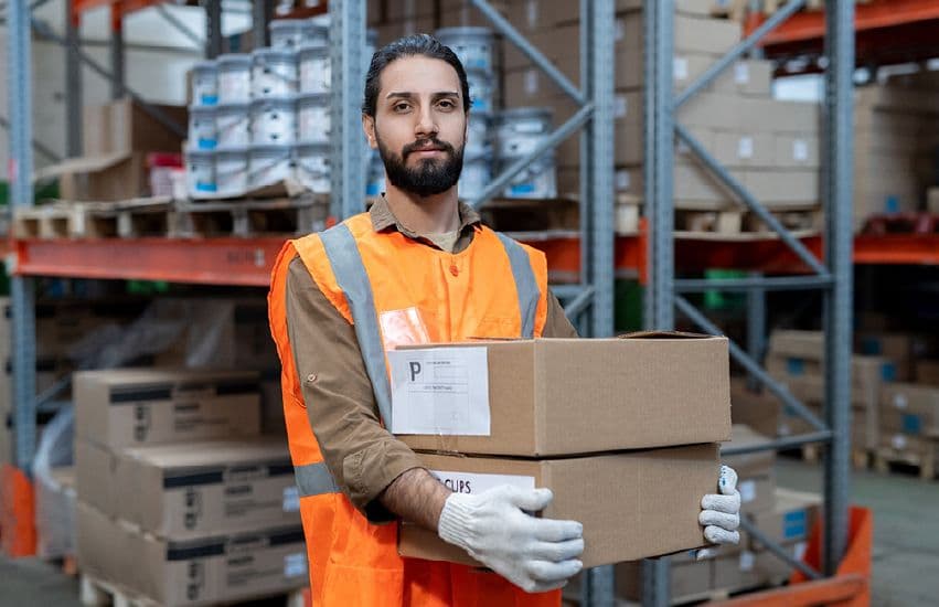Warehouse worker holding boxes in a storage facility